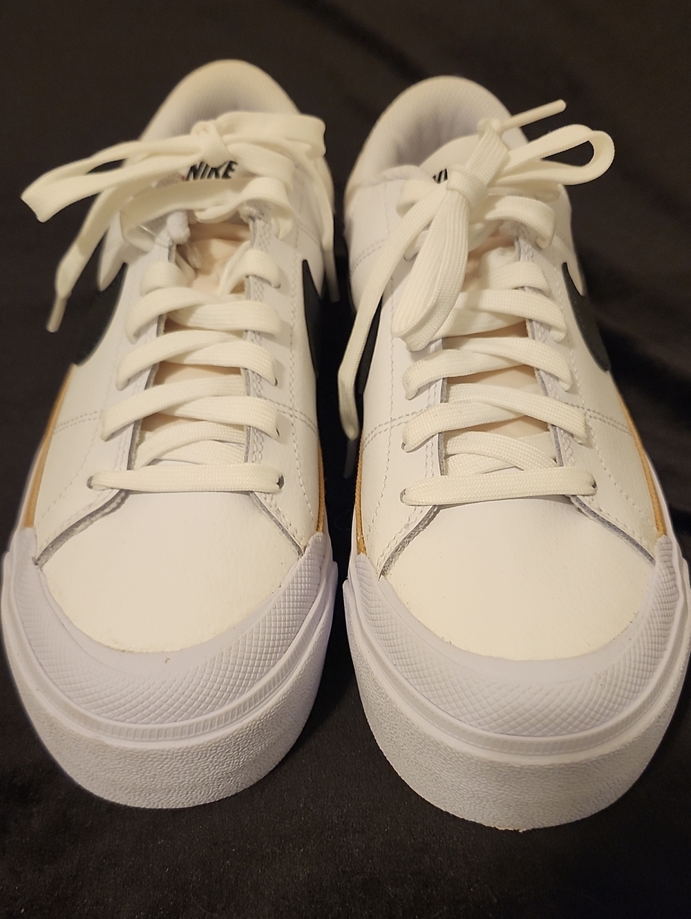 Nike White Sneakers with Black Swoosh and Gold Accent